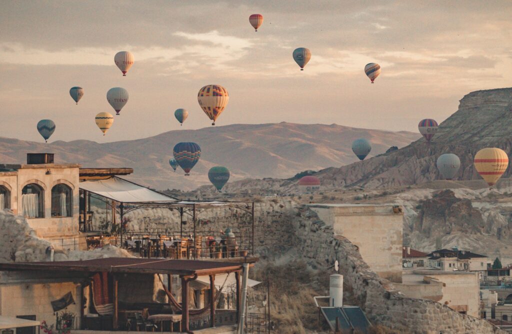 Sunrise hot air balloons floating above the valleys and rock formations of Cappadocia in Turkey