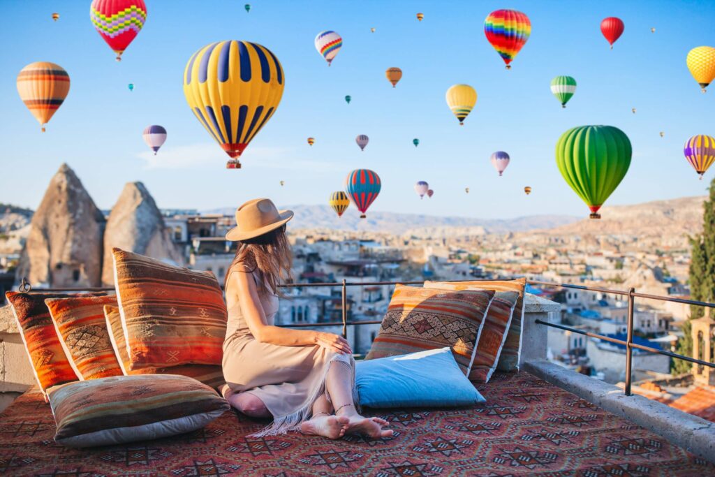 Hot air balloons rising over the remarkable landscapes and stone dwellings of Cappadocia at sunrise