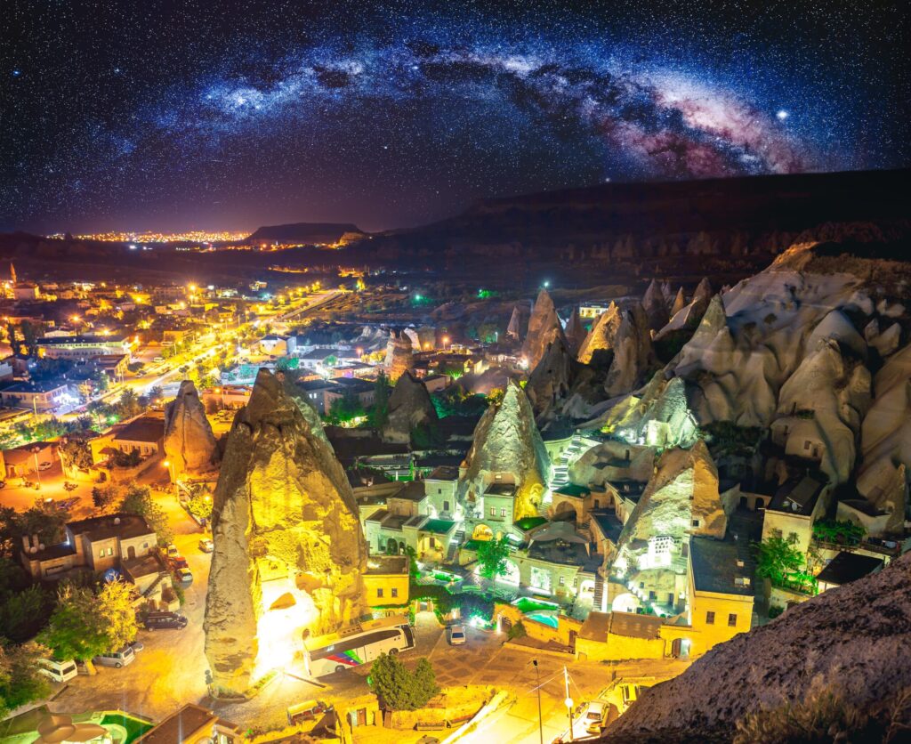 Cappadocia Tours in Turkey Night view of Cappadocia featuring illuminated cave dwellings and volcanic rock formations beneath night sky
